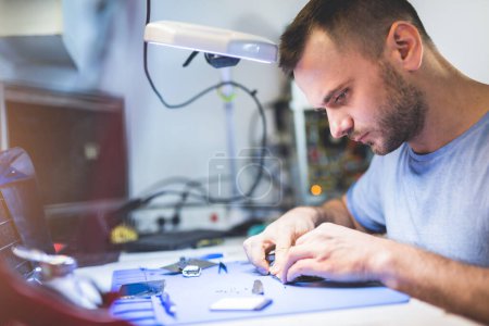 Man repairing mobile phone electronics service and maintenance shop