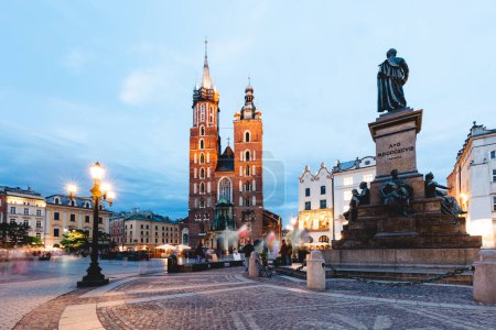 Cracovia, Polonia casco antiguo con la Basílica de Santa María y Adam Mickiewicz monumento en la noche.