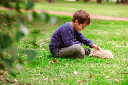 Foto de Little boy with a rabbit in the park - Imagen libre de derechos