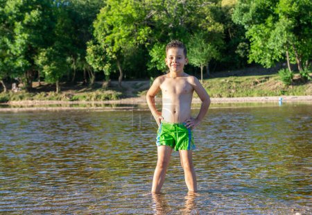 Téléchargez les photos : Happy little boy in the river - en image libre de droit