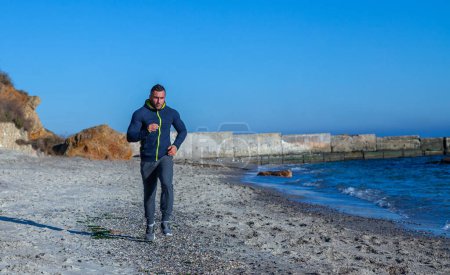 Téléchargez les photos : Male athlete doing sports on the beach - en image libre de droit