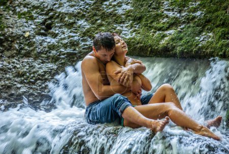 Foto de Happy young couple in love outdoors in the waterfall - Imagen libre de derechos
