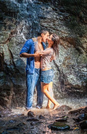 Foto de Happy young couple in love outdoors in the waterfall - Imagen libre de derechos