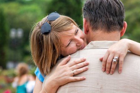 Photo for Young emotional woman hugging her husband in the park - Royalty Free Image