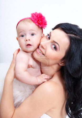 Téléchargez les photos : Mère heureuse avec bébé sur un fond clair - en image libre de droit