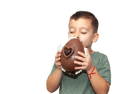 Foto de Niño feliz con huevo de chocolate de Pascua sobre fondo claro - Imagen libre de derechos