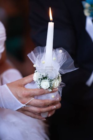 Téléchargez les photos : Bougie brûlante dans les mains de la mariée - en image libre de droit