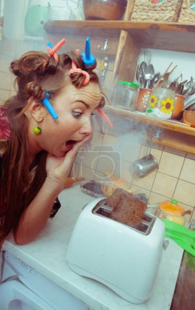 Photo for Housewife with toaster in the kitchen - Royalty Free Image