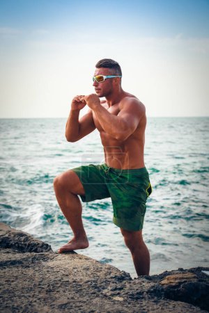 Téléchargez les photos : Homme de sport sur la plage en saison estivale - en image libre de droit