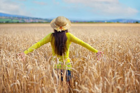 Téléchargez les photos : Jeune fille dans un chapeau dans un champ de blé - en image libre de droit