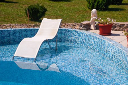 Téléchargez les photos : Chaise longue près de la piscine d'eau - en image libre de droit