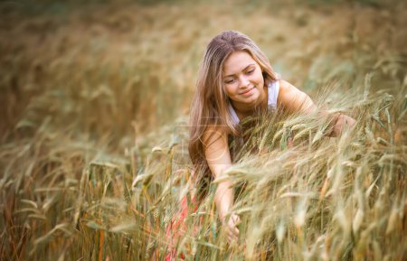 Téléchargez les photos : Fille heureuse dans un champ de blé - en image libre de droit