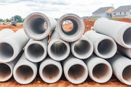 Photo for New concrete pipes stacked on a construction site. Preparation for the manufacture of the sewer system. - Royalty Free Image
