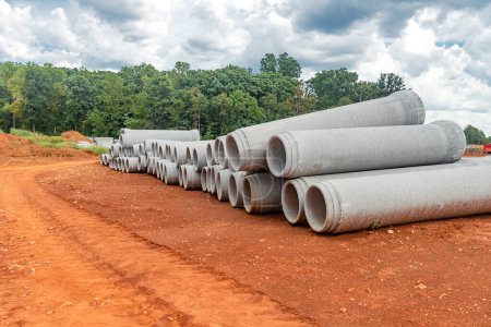 Photo for Set of new pipes stacked on yellow clay at a construction site. - Royalty Free Image
