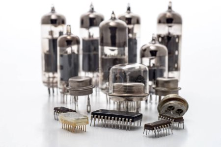 Foto de Microchips de componentes de radio, transistores y tubos de radio sobre fondo blanco. El concepto de la evolución de la radioelectrónica. - Imagen libre de derechos