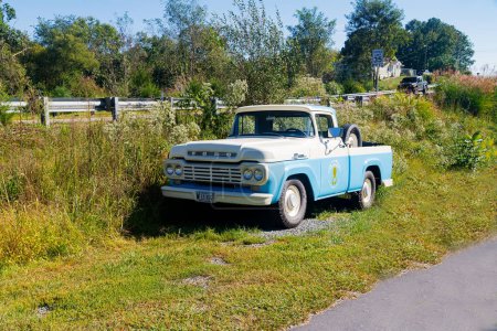 Foto de Ford F100 camioneta antigua camioneta estacionada en un campo agrícola a lo largo de la carretera azul. - Imagen libre de derechos