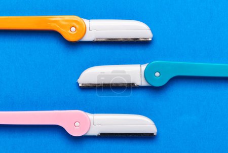 Photo for Multicolored razor shavers. Colored razors shavers, on a blue background. copy space for text. View from above. - Royalty Free Image