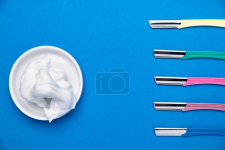 Photo for Image of beautiful multicolored razor shavers. Colored razors shavers, on a blue background and shaving Gel. copy space for text. View from above. - Royalty Free Image