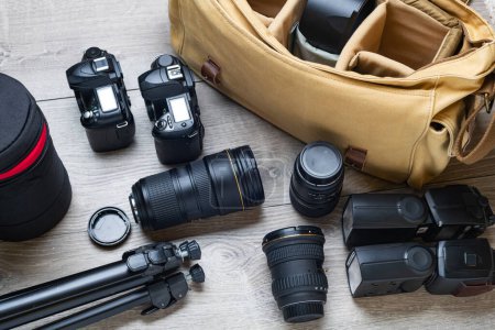 Téléchargez les photos : Flashs, appareils photo, objectifs, trépied et sac de photographe sont prêts à être emballés. - en image libre de droit