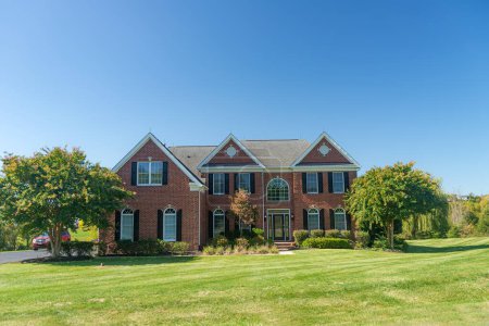 Téléchargez les photos : Large brick house with a green lawn. Landscape on a summer sunny day. - en image libre de droit