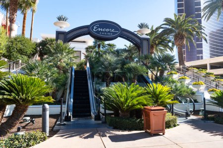 Foto de Palmeras, escalones y escaleras mecánicas en el casino Encore en Las Vegas. Un lugar de atracción para los turistas. - Imagen libre de derechos