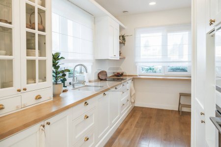 Foto de Hermosa cocina blanca espaciosa y luminosa hecha en estilo clásico - Imagen libre de derechos