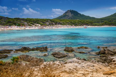 Playa de Cala Agulla en Mallorca, mostrando su costa, aguas azules claras y entorno natural