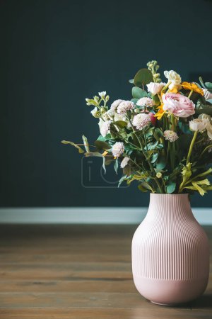 Un arreglo floral elegante en un jarrón rosa sobre un fondo oscuro, que ofrece una estética elegante y sofisticada para el estilo interior. Concepto: decoración del hogar y diseños florales