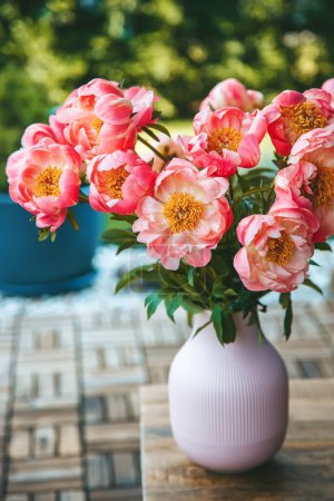 Téléchargez les photos : Pivoines roses luxuriantes remplissent un vase rose avec crête verticale, créant un affichage vibrant - en image libre de droit
