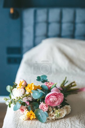 Téléchargez les photos : Un beau bouquet de différentes fleurs couchées sur un lit, évoquant un sentiment de fraîcheur et d'élégance - en image libre de droit