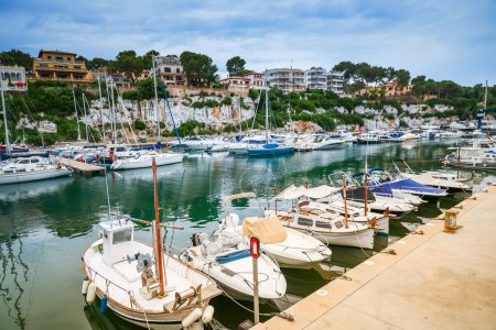 Téléchargez les photos : Une vue sereine sur le port de Porto Cristo à Majorque, mettant en valeur les bateaux amarrés et le paysage environnant - en image libre de droit
