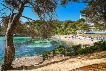 Beautiful Font de Sa Cala beach in Mallorca, full of people enjoying the sea and the sun