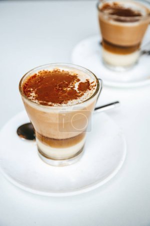 Barraquito - una popular bebida de café en capas de Tenerife, con espresso, leche condensada, leche espumosa y un toque de Licor 43, decorado con cáscara de limón y canela