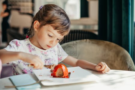 Ein kleines Mädchen genießt ein Stück Kuchen, das die einfache, aber tiefe Freude an den kleinen Freuden des Lebens veranschaulicht