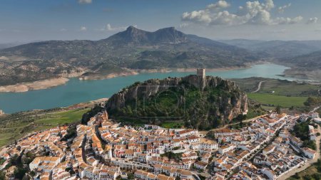 Foto de Flying over the orange roofs of the town, fortress on the mountain and the view of the river in Zahara de la sierra. - Imagen libre de derechos