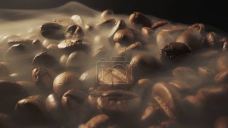 Slider shot of coffee beans during roasting. Smoke comes from fresh coffee seeds. Macro shot, 4K