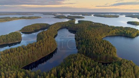 Téléchargez les photos : Survoler les lacs en Finlande. Vue aérienne de nombreuses îles vertes au coucher du soleil - paysage finlandais classique. Lac finlandais terre dans les lumières du coucher du soleil. Îles vertes et lac avec reflet nuageux. 4K, UHD 2 - en image libre de droit