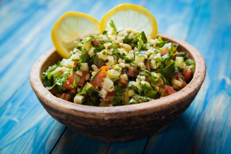 Photo for Lebanese tabbouleh salad with bulgur, parsley, cucumber, tomato, lemon and olive oil - Royalty Free Image