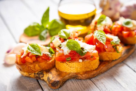 Téléchargez les photos : Brochette italienne classique tranches de pain grillées avec tomate, basilic et fromage mozzarella - en image libre de droit