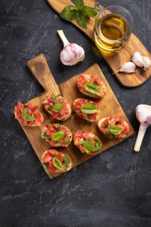 Photo for Classic italian bruschette grilled bread slices with tomato and basil - Royalty Free Image