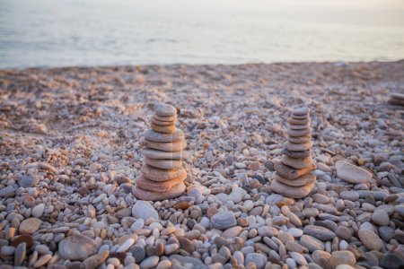 Foto de Pirámide de piedras de armonía equilibrada en la costa de la playa. Luz del atardecer de verano. Concepto de meditación zen. - Imagen libre de derechos