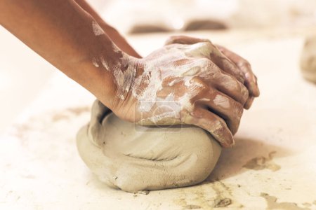 Téléchargez les photos : Artiste de poterie féminine préparant l'argile pour le moulage. Vue rapprochée des mains de femme avec de l'argile. Artisanat artisanal créatif. - en image libre de droit