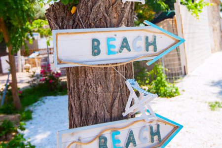 Photo for Vintage beach wooden sign on a tree in the garden. Summer travel holiday concept. - Royalty Free Image