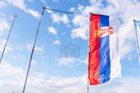 Téléchargez les photos : Le drapeau serbe agitant fièrement contre le ciel bleu est un signe de fierté nationale et de célébration de la fête de l'indépendance. - en image libre de droit