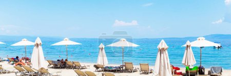 Foto de Vacaciones de verano y concepto de viaje - Tumbonas y sombrillas en la playa de arena de lujo - Hermoso mar de fondo - Estilo de vida relajante - Imagen libre de derechos