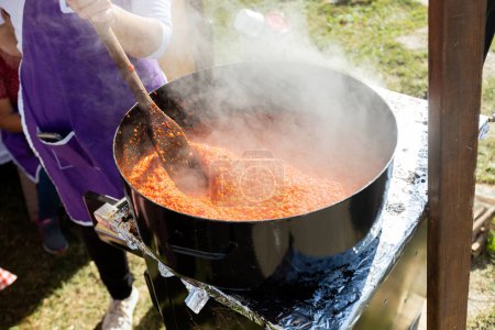 Téléchargez les photos : Processus de fabrication des aliments des Balkans par le poivron rouge rôti, propagation appelée Ajvar, préparation traditionnelle. - en image libre de droit