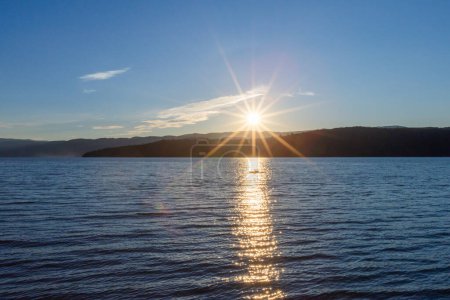 Téléchargez les photos : Coucher de soleil serein scène d'eau, horizon ensoleillé et réflexion tranquille. - en image libre de droit