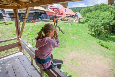 Photo for Child prepared for a zipline ride at the adventure park. - Royalty Free Image