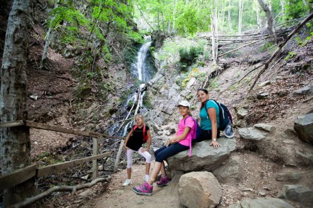 Téléchargez les photos : Plaisir d'été à la cascade de la forêt pour une famille heureuse. - en image libre de droit
