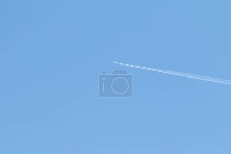 Téléchargez les photos : High in the blue sky the trail of an airplane - en image libre de droit